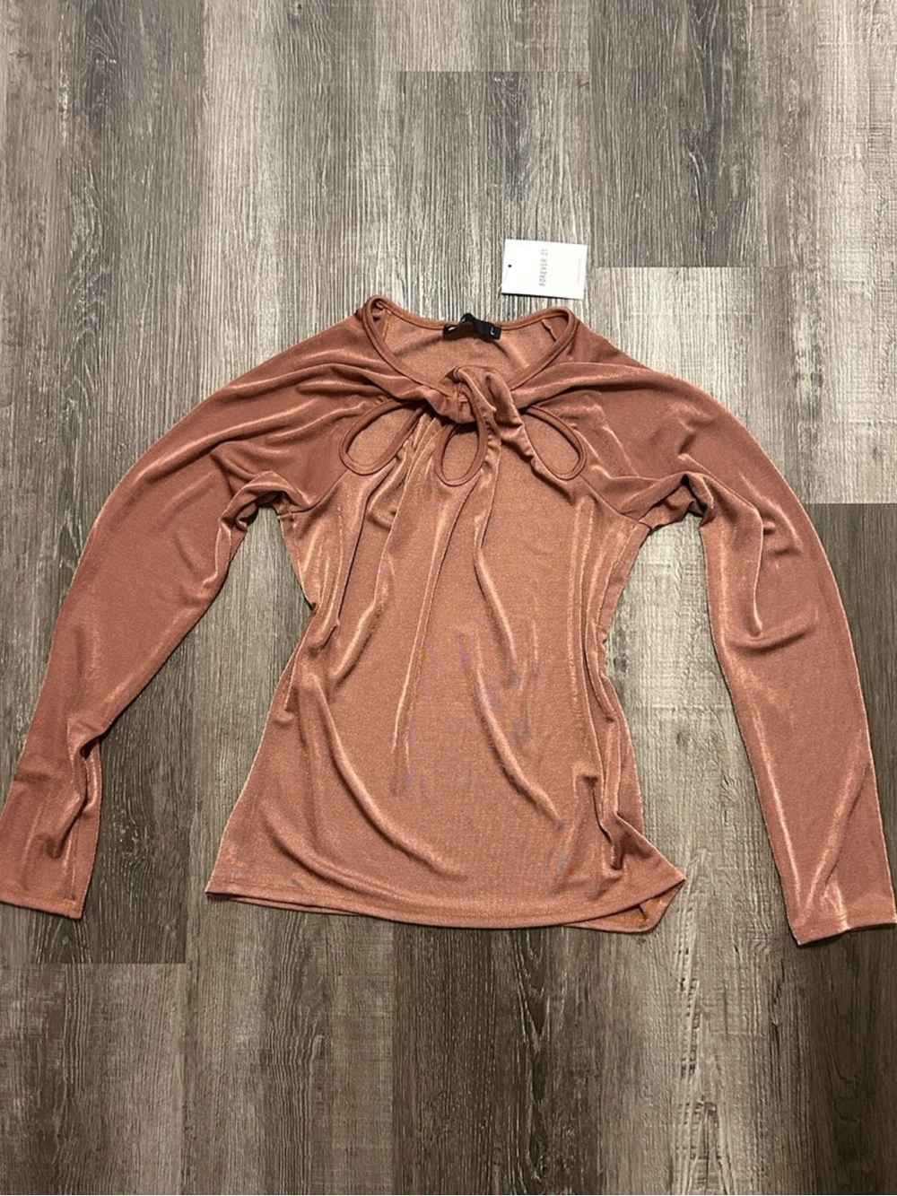 3$10 bronze long-sleeved shimmer top featuring gathered knot detail